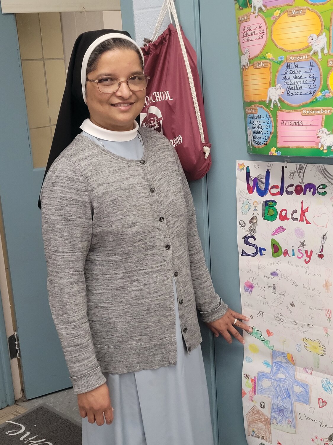 WELCOME BACK BANNER: St. Rocco second grade teacher and nun St. Rocco’s Sister Daisy Kollamparampil shows off the “Welcome Back” banner she received when she came back to work after recovering from an accident on Nov. 7.